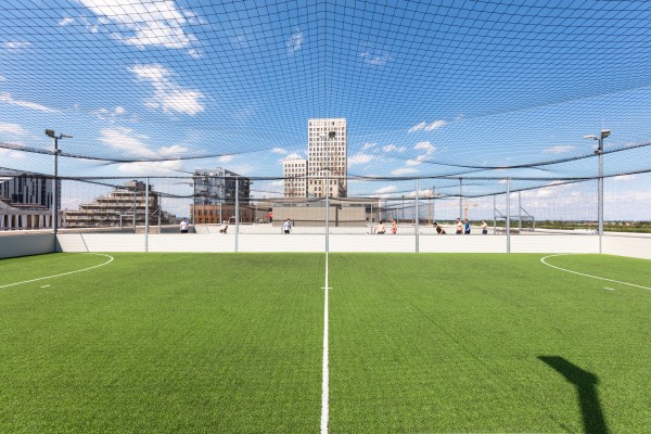 Fußballfeld
                                    auf einem Dach, im Hintergrund andere Gebäude. 