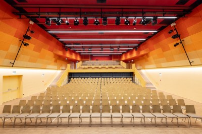 Modernes Theater mit Sesselreihen und im Hintergrund die große Bühne