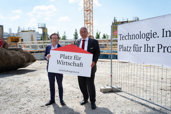 Gerhard Hirczi, Geschäftsführer der Wirtschaftsagentur Wien, und Ernst Nevrivy, Bezirksvorsteher der Donaustadt, beim Spatenstich mit einem Schild "Platz für Wirtschaft". 