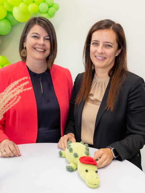 Zwei Frauen an einem Stehtisch vor grünen Ballons